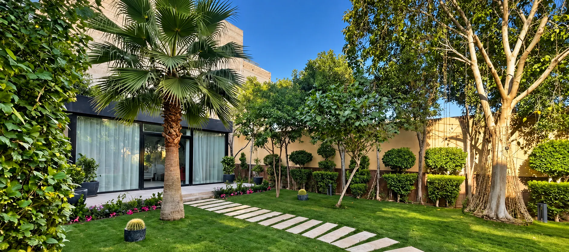 A Ghusn garden in Riyadh by day: lawn, palms and a stepping-stone path